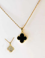 Close-up of dainty gold clover charm with dual finish