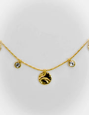 Close-up of twisted gold chain with tiny gold charms and zircons