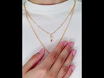Montreal-style gold pendant necklace flat lay on white background video