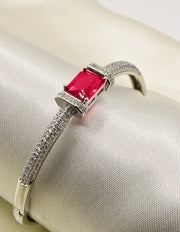 “Scarlet Glow Crystal Loom Bracelet with ruby-red centre stone, silver band, and pavé-set accents – luxury women’s jewellery Canada.”