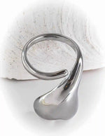 Close-up of silver love drop ring reflecting soft light