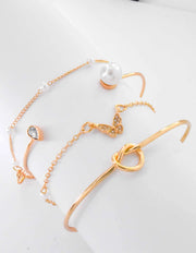 Elegant knot bangle and pearl-accented gold chain bracelet set