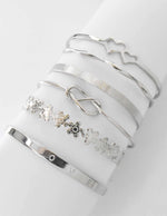 Top view of silver LOVE engraved bangle and floral bracelet combo
