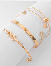 Gold permanent bracelet stack with LOVE engraved centrepiece