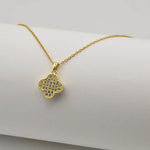 Dainty clover golden pendant necklace on white background