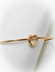 Polished gold bangle stack featuring open heart charm