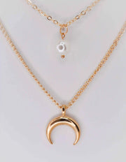 Double strand gold necklace featuring moon and pearl pendants