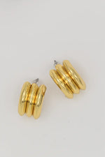 Side view of triple-layer gold conch hoop earrings
