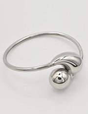 Silver bangle bracelet paired with dainty gold bar necklace