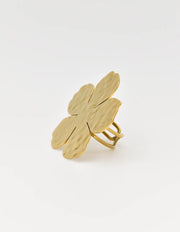 Five-petal gold flower ring next to coastal shell for elegance