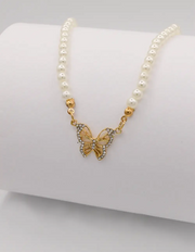 delicate_pearl_and_gold_butterfly_necklace_displayed_on_white_background