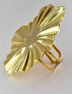 Gold leaf-shaped brooch on a light gray background