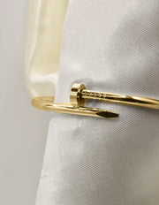 Close-up of gold twist nail bangle bracelet with smooth polished finish, Canadian chic.